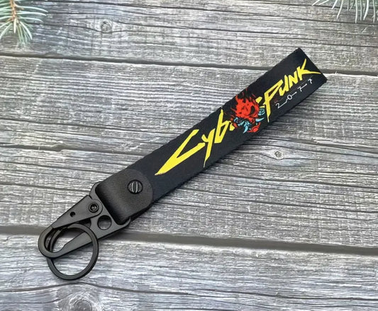 Cyberpunk 2077 keychain with flame design on black strap.