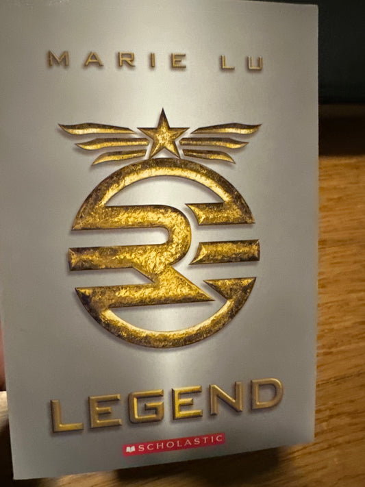 Marie Lus Legend book cover with gold emblem and star.