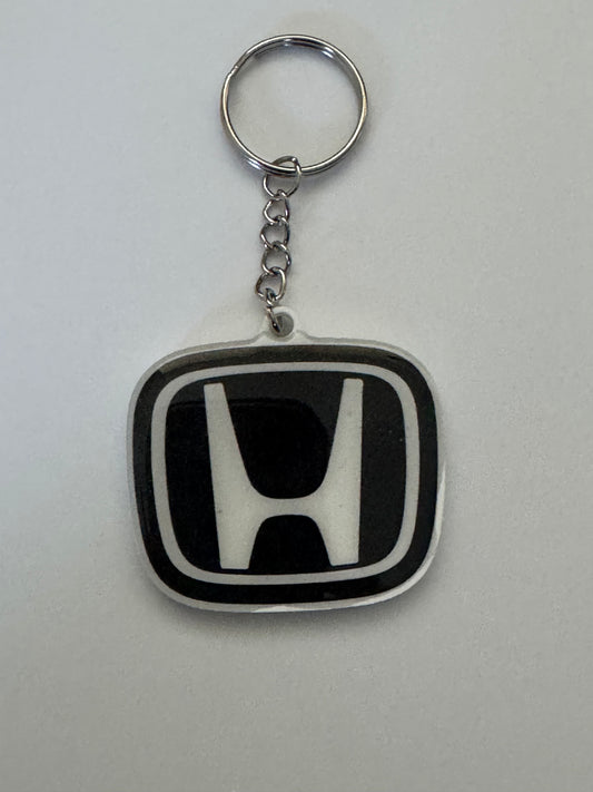 Honda logo keychain with silver ring and chain on a white background.