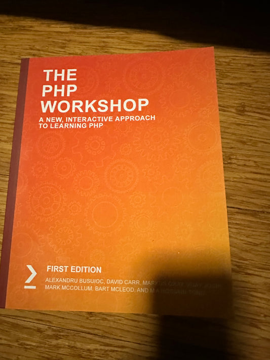 Cover of The PHP Workshop book with orange gears design on wooden surface.
