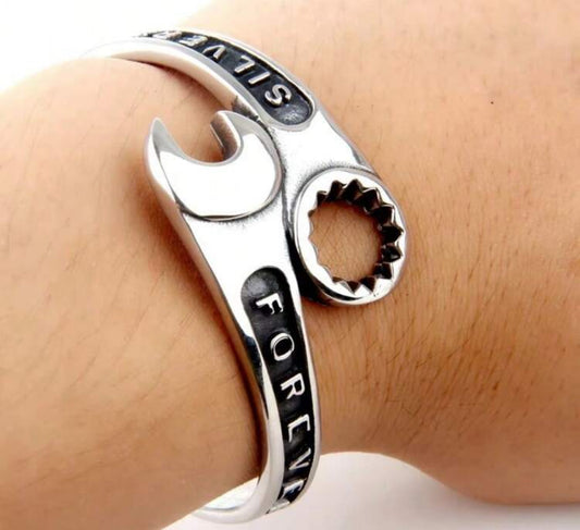 Silver wrench-shaped ring with ALWAYS and FOREVER inscribed on it.