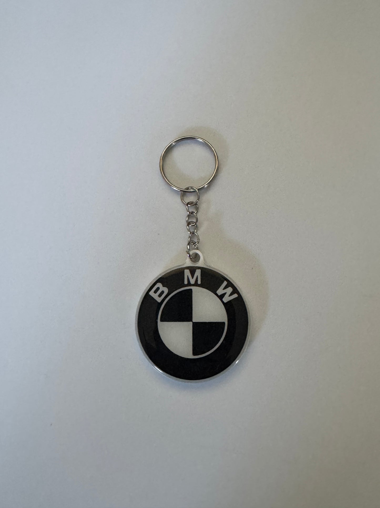 Black and white BMW logo keychain with silver ring on a plain background.