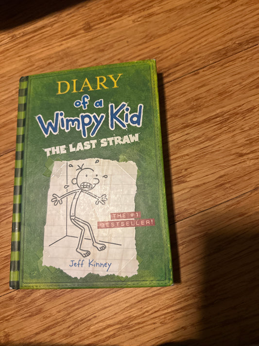 Diary of a Wimpy Kid The Last Straw book cover on wooden surface