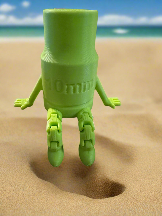 Green 3D-printed toy figure with 10mm text, standing on sandy beach.