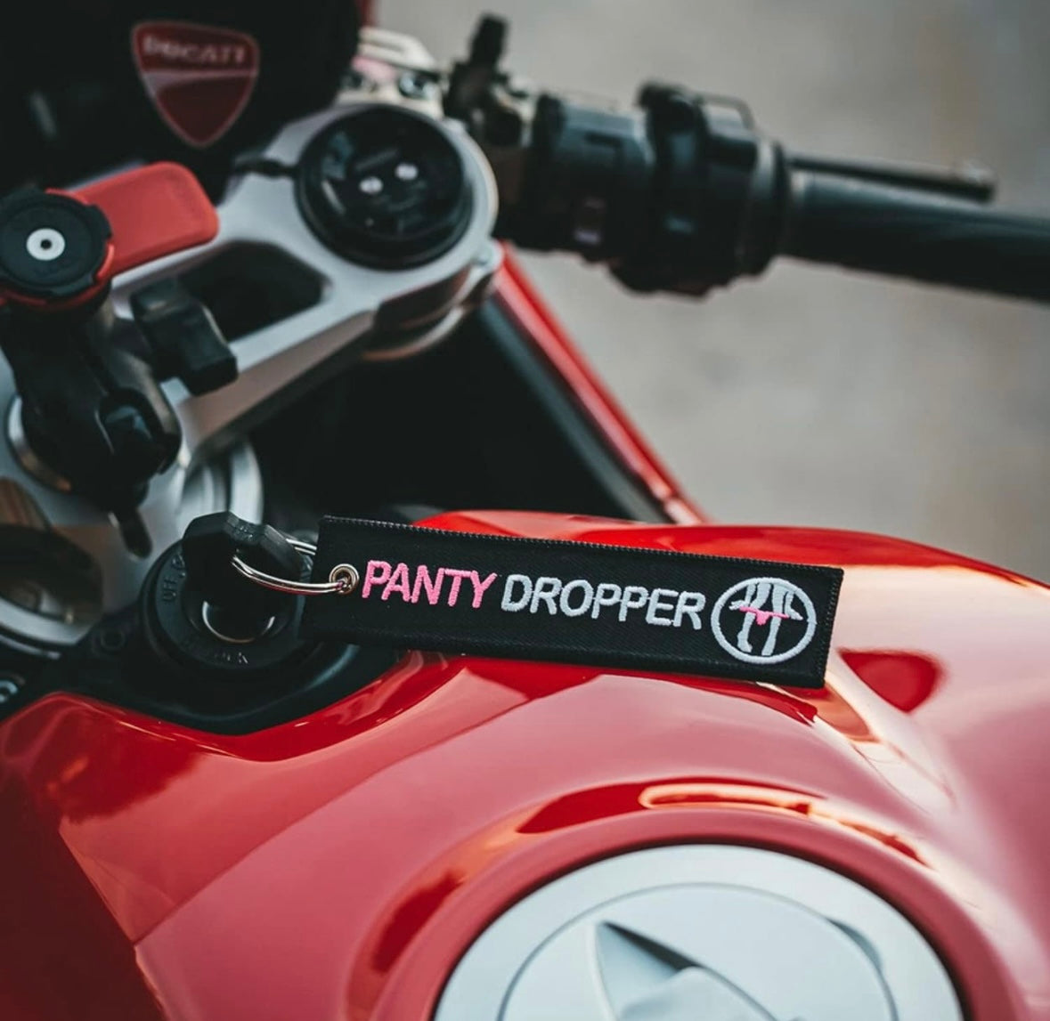 Black keychain with PANTY DROPPER and logo on a red motorcycle fuel tank.