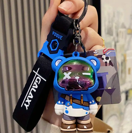 Blue astronaut keychain with Vogue strap and colorful design.