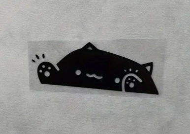 Black cat sticker with whiskers and a cute expression on white background.