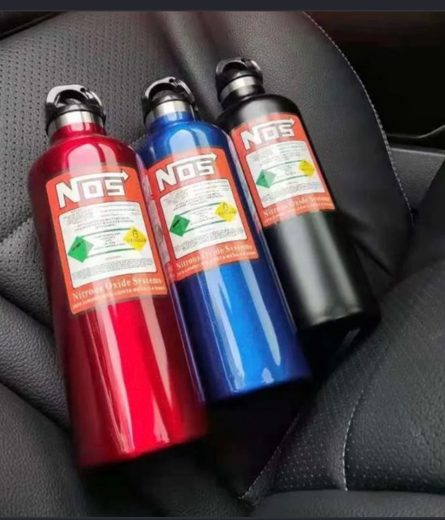 Three NOS nitrous oxide bottles in red, blue, and black on a car seat.