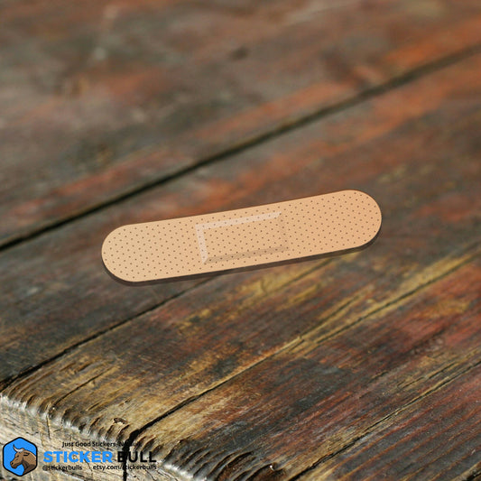 Small adhesive bandage on wooden surface.