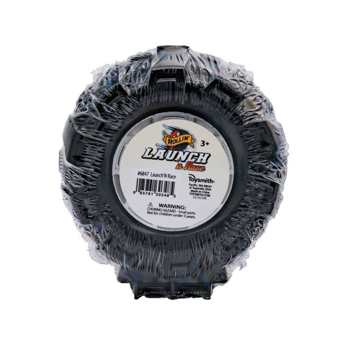 Black plastic toy tire with Launch n Race label and warning sticker.