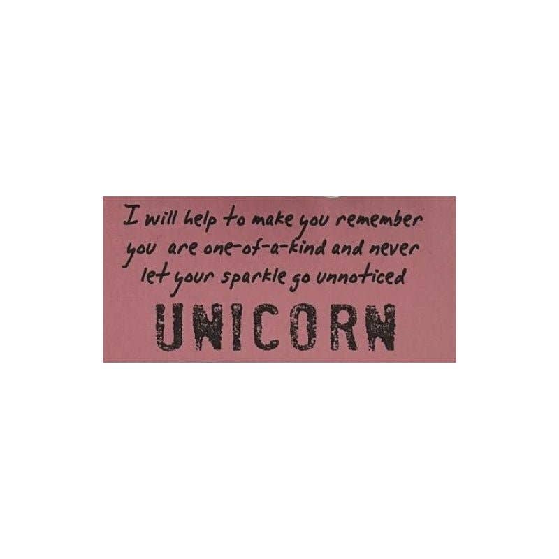 Pink sign with motivational unicorn quote on white background.