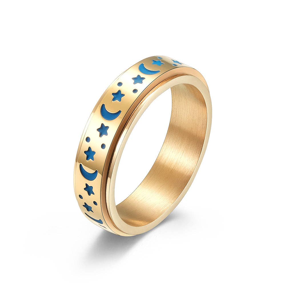 Gold ring with blue moon and star designs on a white background.