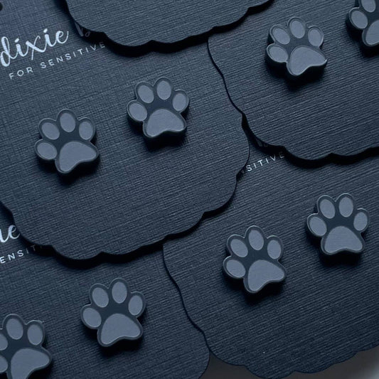 Black paw print stickers on dark textured background.