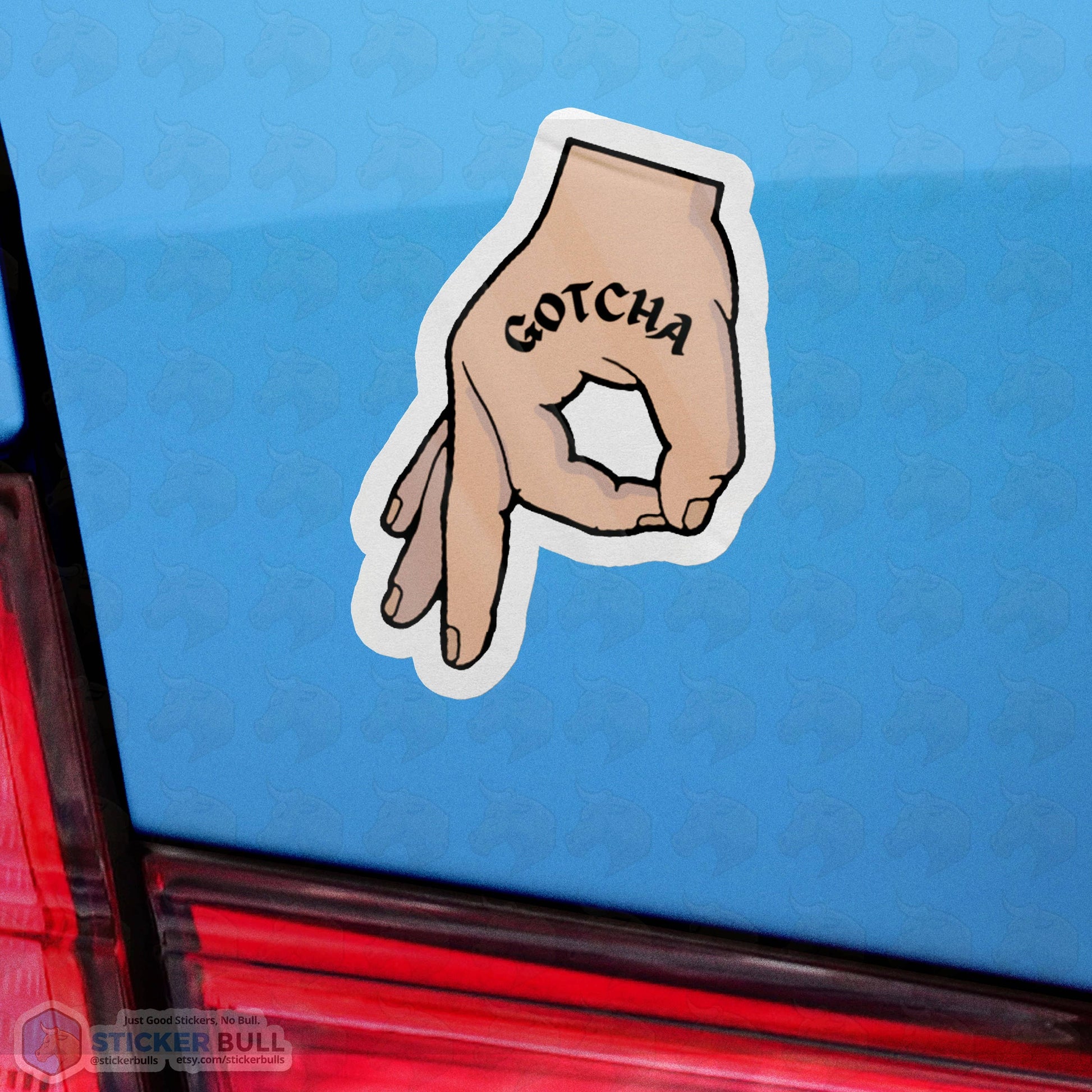 Gotcha hand gesture sticker on blue car window